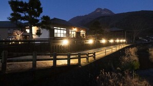 Une maison avec une terrasse en bois et une montagne en arrière-plan.