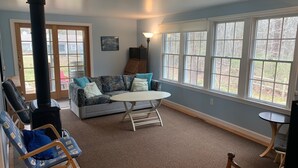 A cozy living room with a sofa, a table, a chair, and a fireplace. - Less Than 1 Mile to Point of Rocks Beach (2186) (Brewster)