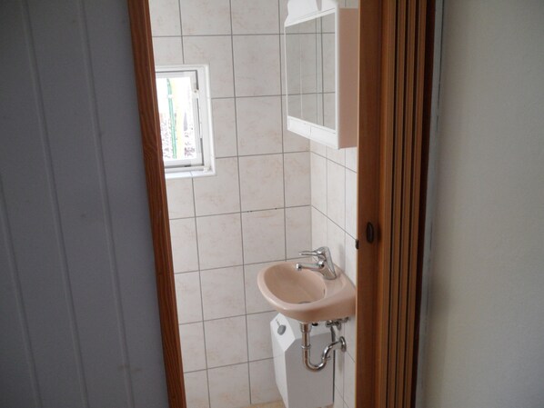 A bathroom with a sink, mirror, and window. - Vacation homes in the hamlet of Krüger with private lake access (Wuthenow)