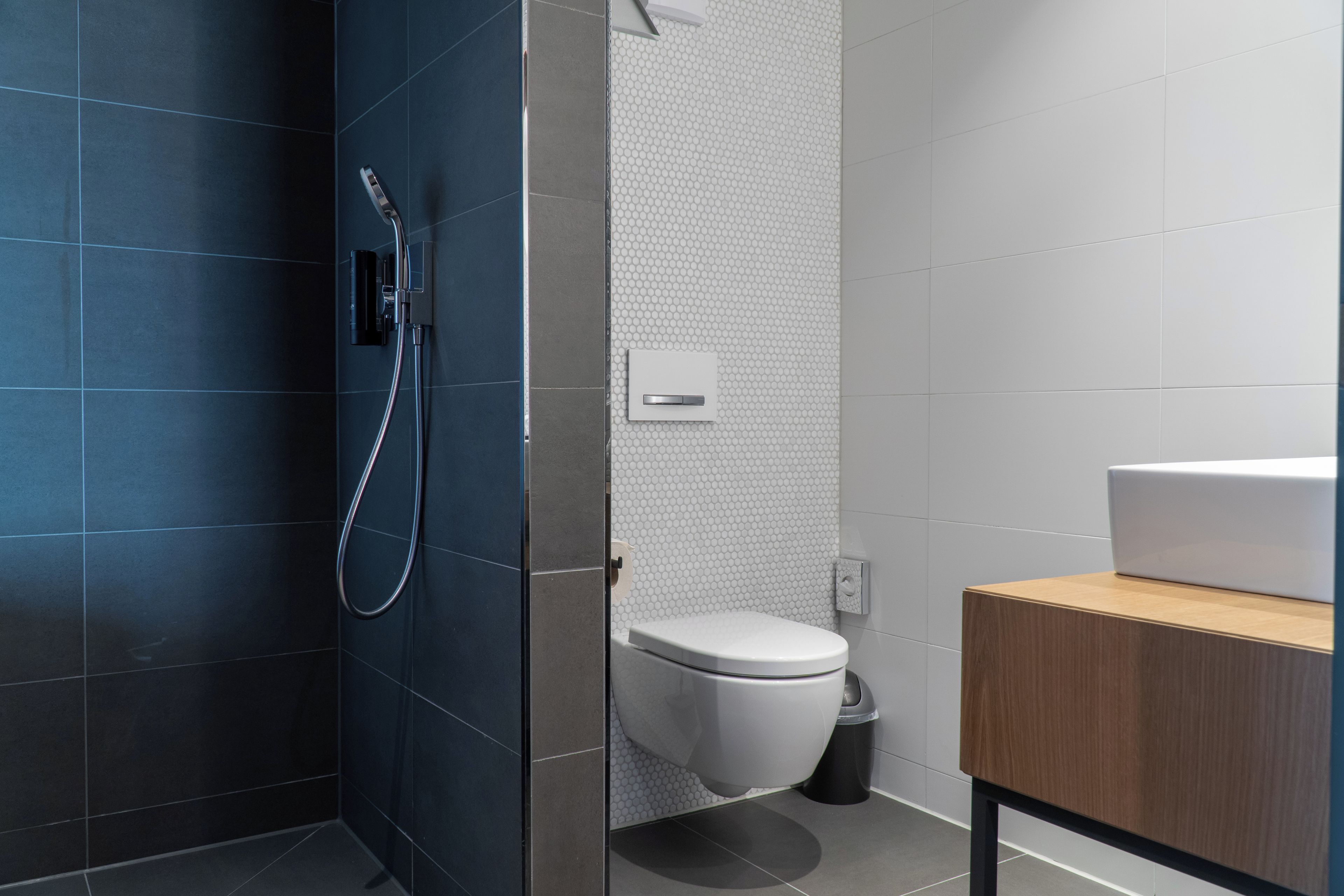 Un baño moderno con ducha, inodoro y lavamanos.