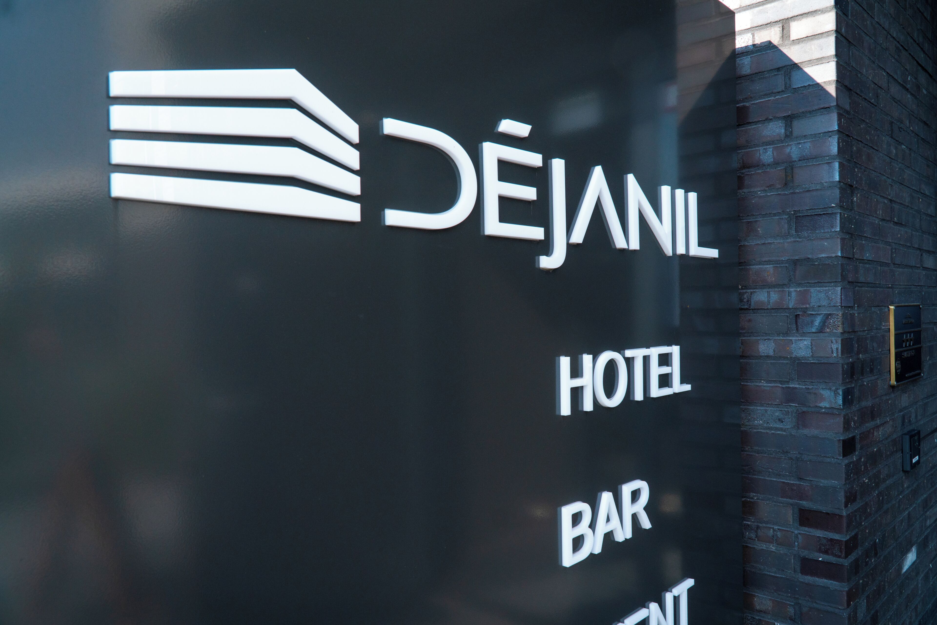 Señal de hotel con el nombre 'DEJANIL' y la indicación 'HOTEL BAR', lo que indica la presencia de un bar dentro del hotel.