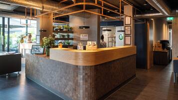 Un mostrador de recepción de diseño curvo, piso de baldosas y vista al exterior a través de amplios ventanales.