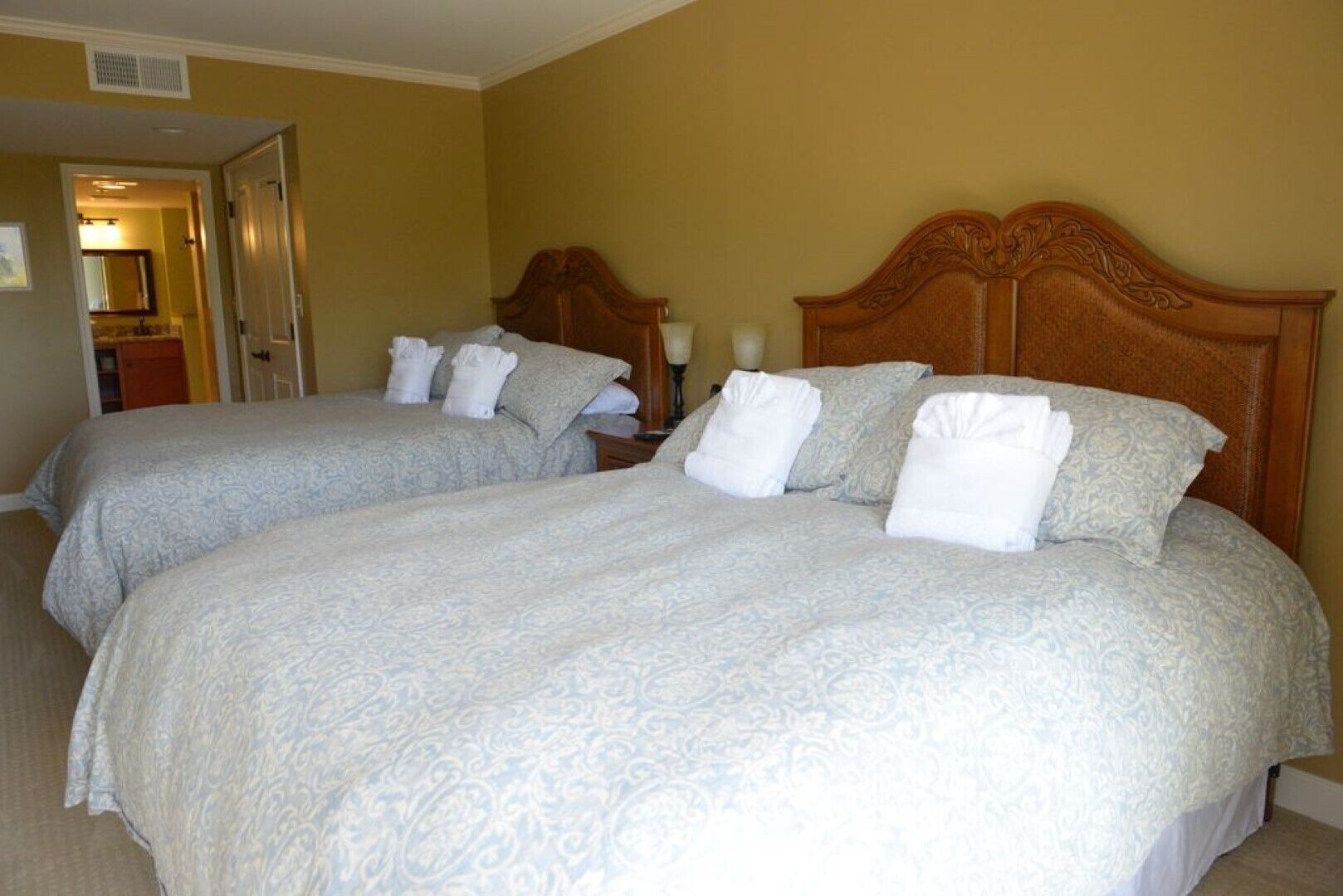 Una habitación de hotel con dos camas, cada una con cabecero de madera y ropa de cama a juego.
