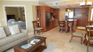A living room with a sofa, coffee table, and a dining area with chairs and a table. - 3326 Villamare -Ocean Front Villa Complex  - Fully Renovated and New Pools! (Hilton Head Island)