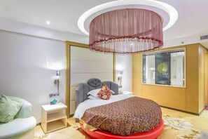 A modern hotel room with a bed, bedside table, and a large mirror.