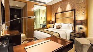 A hotel room with a large bed, a wooden desk, a nightstand, and a chair. - Hanxin International Hotel (Panjin)