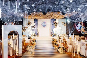 Un área de recepción con una escalera central, asientos y un fondo decorativo.