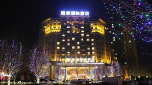 A hotel with a traditional architectural style, featuring a prominent entrance and multiple floors. - Hanxin International Hotel (Panjin)