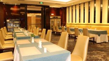 A banquet hall with long tables, chairs, and a carpeted floor.