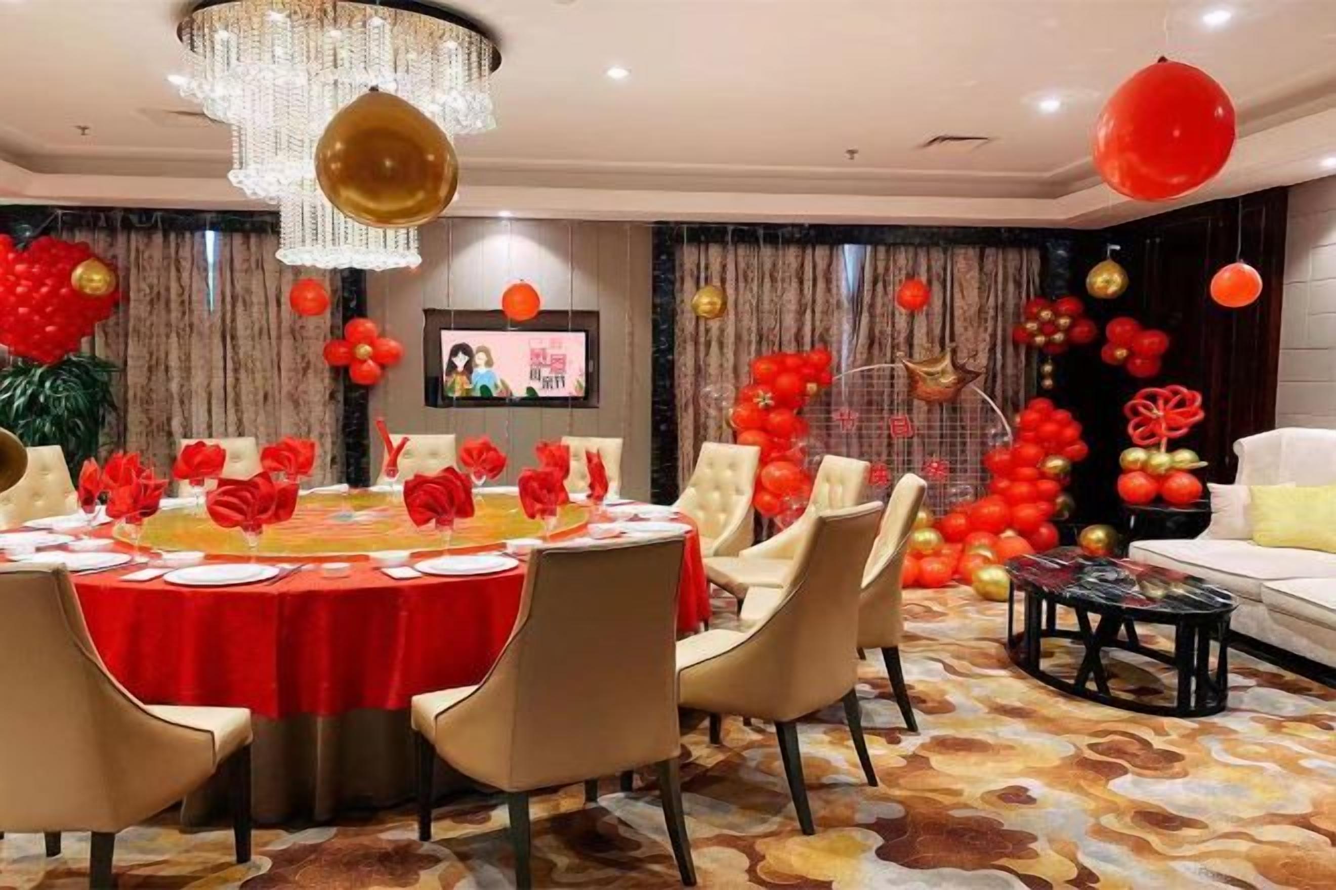 Une salle de banquet avec une table ronde, des chaises et un lustre.