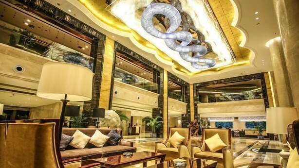 A spacious lobby with a modern chandelier, comfortable seating, and a large glass wall offering views of the interior. - Hanxin International Hotel (Panjin)