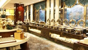 A buffet area with multiple serving stations, a central counter, and decorative mirrors. - Hanxin International Hotel (Panjin)