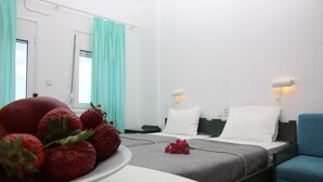 A hotel room with a bed, a chair, a table with strawberries, and a bouquet of flowers. - La Palma II (Malevizi)