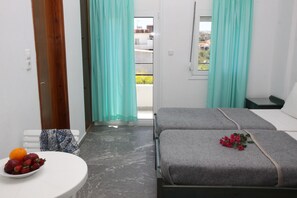 A hotel room with two beds, a small table with fruit, a view of the outside, and teal curtains. - La Palma  IV (Malevizi)