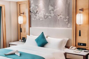 Habitación de hotel con cama, mesitas de noche, teléfono en la pared y un adorno decorativo.