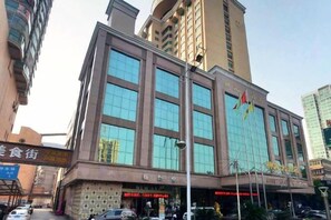 A multi-story building with large windows and a sign indicating a hotel. - Shen Long Hotel (Hengyang)