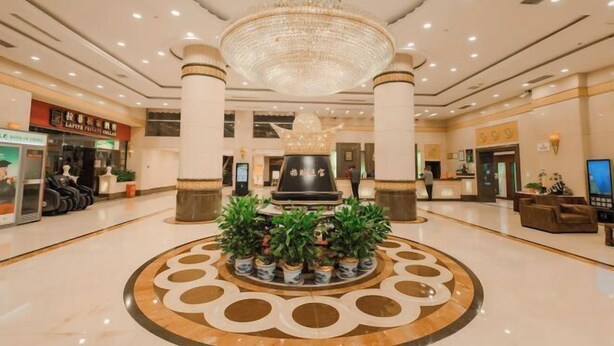 A hotel lobby with a central fountain, a chandelier, and a reception desk. - Shen Long Hotel (Hengyang)