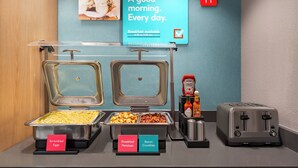 Ein Frühstücksbuffet mit Rührei, Frühstückskartoffeln und Speckbröseln.