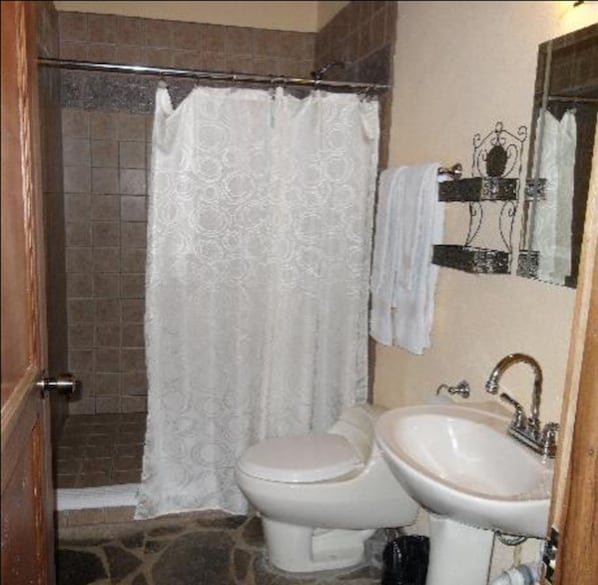 A bathroom with a shower, toilet, and sink. - Hacienda La Isla (Las Horquetas)