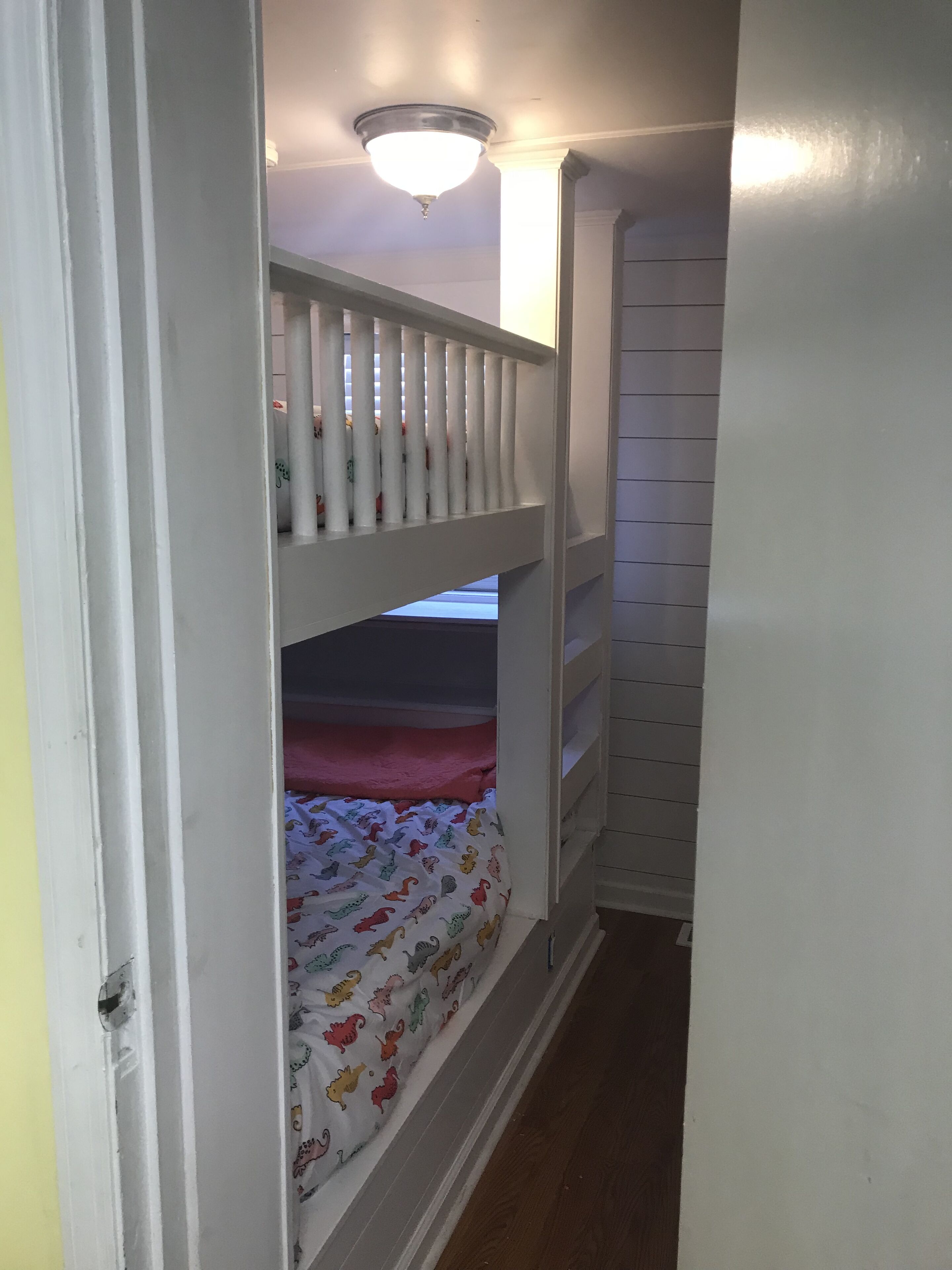 A narrow hallway with a bunk bed in the center.