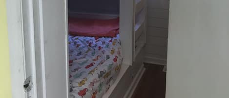 A narrow hallway with a bunk bed in the center.