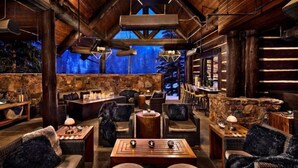 A cozy, rustic interior with stone walls, wooden furniture, and a stone fireplace. - Bachelor Gulch Ritz-carlton Hotel Room With Ski in, Ski out Access, Hot Tub, and Full Service Spa (Avon)