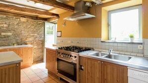 A kitchen with wooden cabinets, a stove, and a window with a view. - Luxury Home in Gouvy With Pool & Sauna (Gouvy)