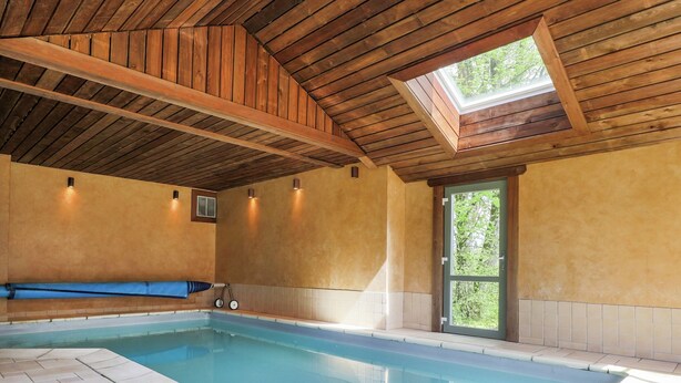 An indoor swimming pool with a wooden ceiling, a bench, and a skylight. - Luxury Home in Gouvy With Pool & Sauna (Gouvy)