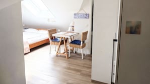 A bedroom with a bed, a table, and two chairs. There is a skylight above the bed, and a sign on the wall that says 'RELAX THE 15 GOOD'. - Apartment at the Rosenhof T301 - T301 (Kühlungsborn)