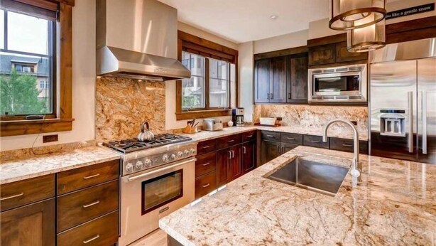 A modern kitchen with granite countertops, stainless steel appliances, and wooden cabinetry. - Spacious 4 Bedroom Vacation Rental in Convenient Location with Scenic Views, Pool, Hot Tub (Breckenridge)