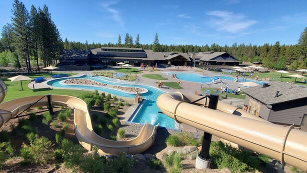 A water park with multiple slides and pools, surrounded by trees and lodge buildings. - LIVE LODGE LIFE- Upscale decor, sleeps 15, hot tub, bikes, 10x SHARC, amazing!! (Sunriver)