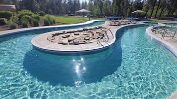 A swimming pool with a circular rock feature and a surrounding deck.