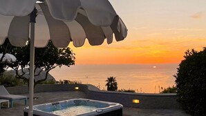A hot tub with a sunset view, stone patio, and outdoor seating. - TRAMONTO: exclusive and panoramic apartment with sea-sunset view in Ischia (Forio)