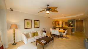 A spacious living area with a white sofa, a wooden coffee table, and a ceiling fan. - Los Suenos Resort Del Mar 4N (Jacó)