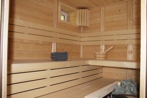Una sauna amb seients de fusta i una petita construcció de fusta.
