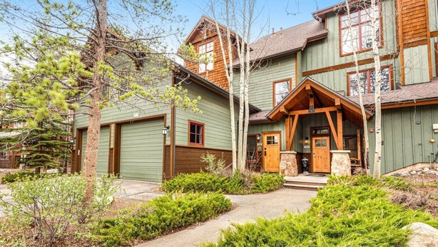 A rustic cabin with a prominent front porch, a stone fireplace, and a well-maintained garden. - Luxury 3 Bedroom Townhouse next to Keystone Lake, Free Shuttle, Hot Tub and Sauna (Keystone)
