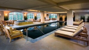 Una amplia piscina cubierta con sillones de descanso y un comedor.