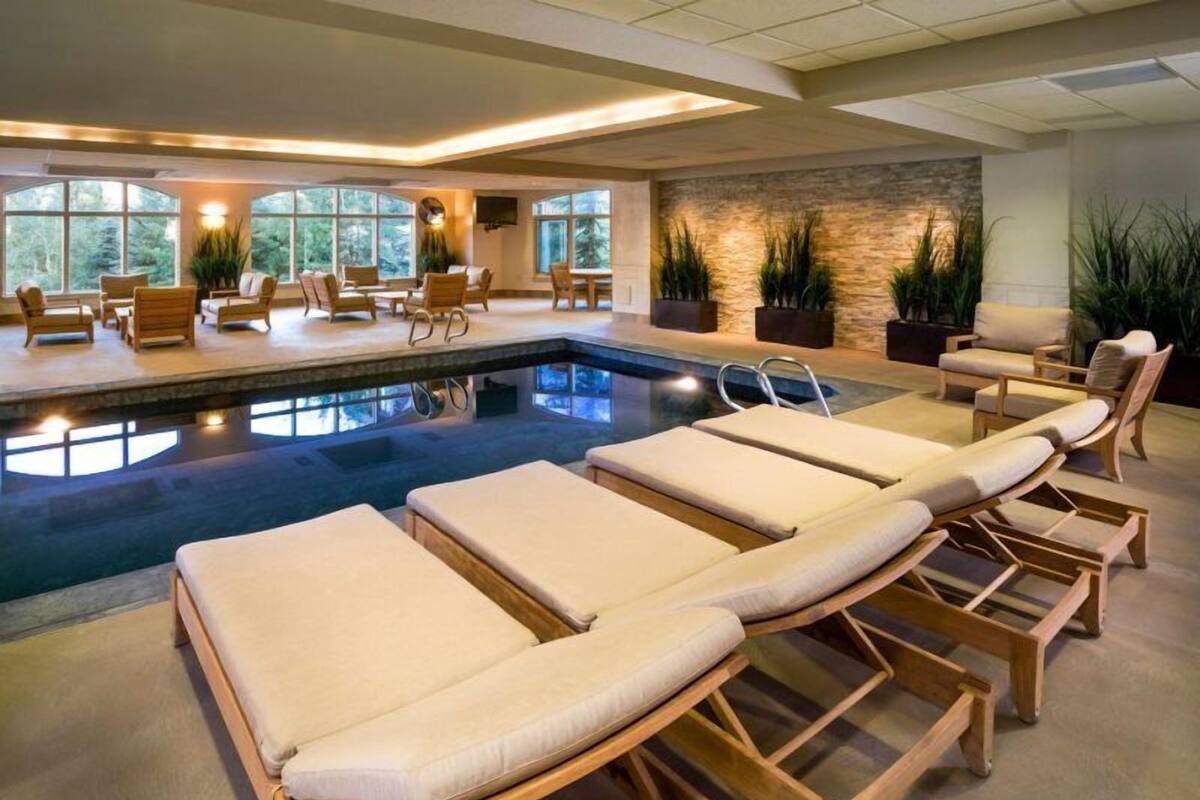 Un espace piscine avec des chaises longues et un mur en pierre.
