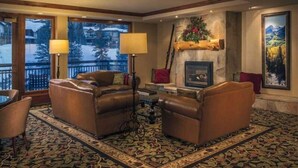 A cozy living room with leather sofas, a fireplace, and a large window overlooking a snowy landscape. - Ski In, Ski Out Studio Condo in the Heart of Lionshead Village with Hot Tubs and Pool (Vail)