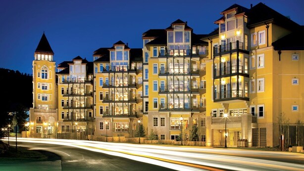A multi-story hotel with balconies, a tower, and a well-lit facade. - Platinum Vail Ritz-carlton 3 Bedroom Mountain Residence Just One Block From the Eagle Bahn Gondola (Vail)
