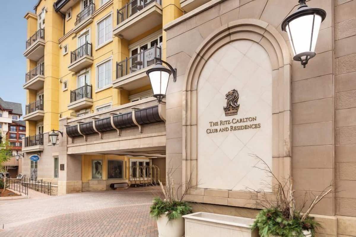 Fachada del edificio Ritz Carlton Club and Residences, con una entrada destacada y un emblema decorativo.