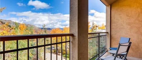 A balcony with a view of autumn foliage and mountains.