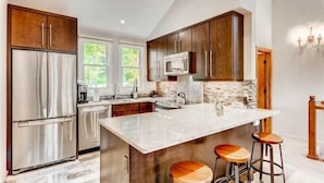 A modern kitchen with a large island, stainless steel appliances, and wooden cabinets. - 2 Bedroom Ski-in Ski-out Condo in Snowmass Village (Snowmass Village)