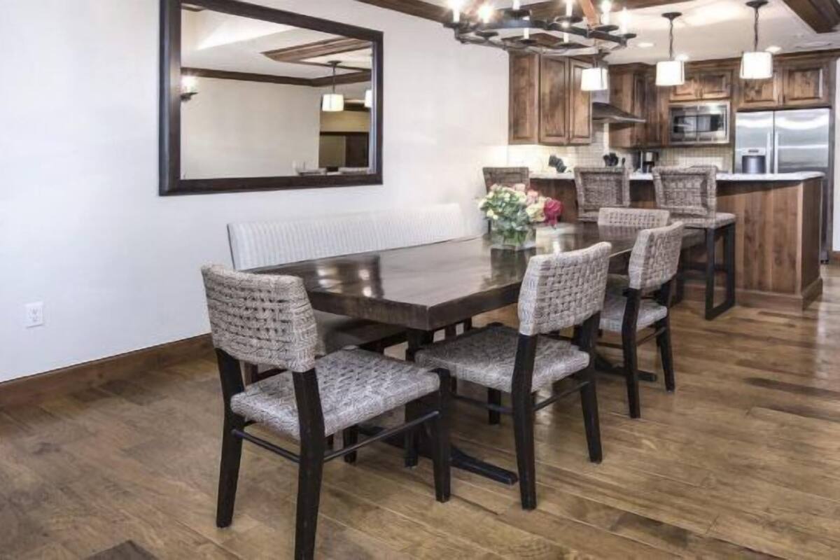 A modern kitchen with wooden cabinets, a central island, and pendant lighting.