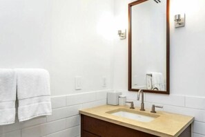 A bathroom with a beige sink, a large mirror, and a towel rack with two towels. - Platinum Vail Solaris 3 Bedroom With Den Vacation Rental Set at the Base of the Mountain Just Steps From the Gondola (Vail)