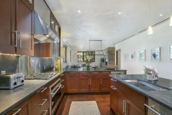 Una cocina moderna con armarios de madera, electrodomésticos de acero inoxidable y una isla grande.