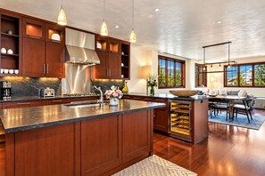 Une cuisine moderne dotée d’un îlot central, de meubles en bois et de luminaires suspendus.