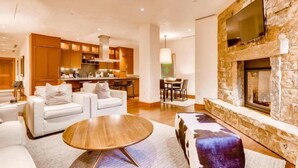 Una sala de estar moderna con chimenea, un comedor y una cocina.