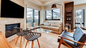 A modern living room with a fireplace, a sofa, and a coffee table. - Vail Lion 1 Bedroom Mountain Vacation Rental Just Steps From the Eagle Bahn Gondola (Vail)