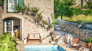 A stone building with a pool, outdoor seating, and a staircase leading to a balcony. - Authentic Villa With Pool on the Island of Brac, Near the Beach (Supetar)